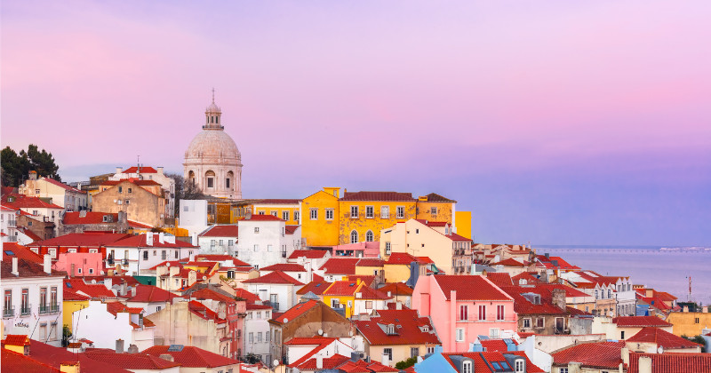 Lisbon under a purple sunset and colourful houses