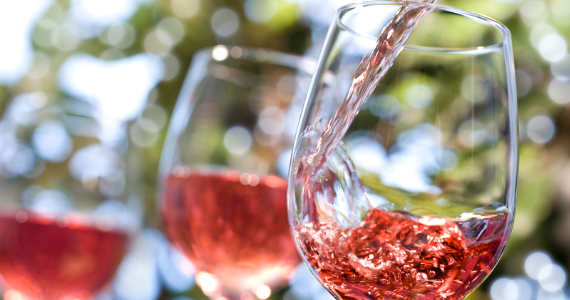 Rosé wine splashing into glass